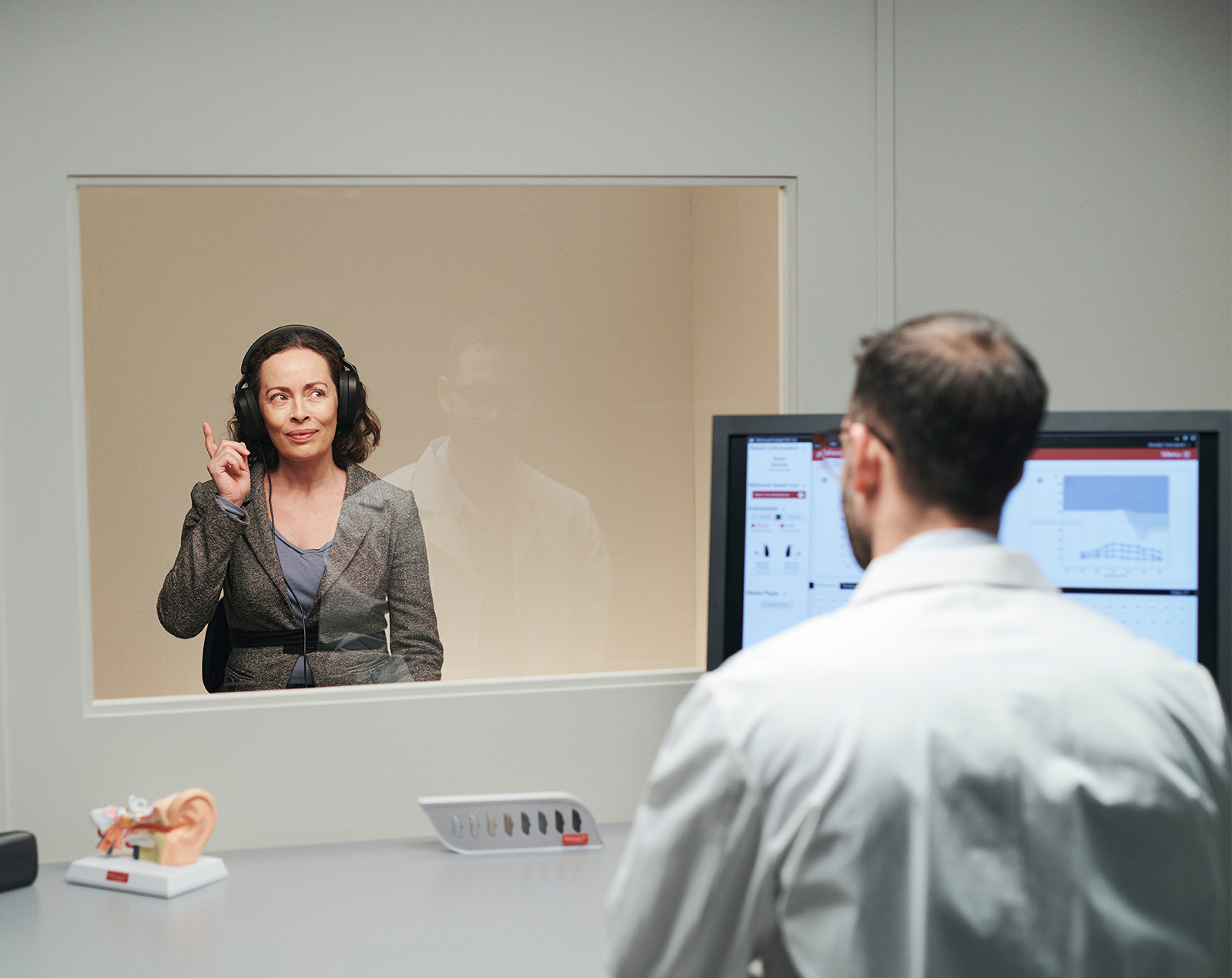 Høreapparatspecialist, der tester en patients hørelse.